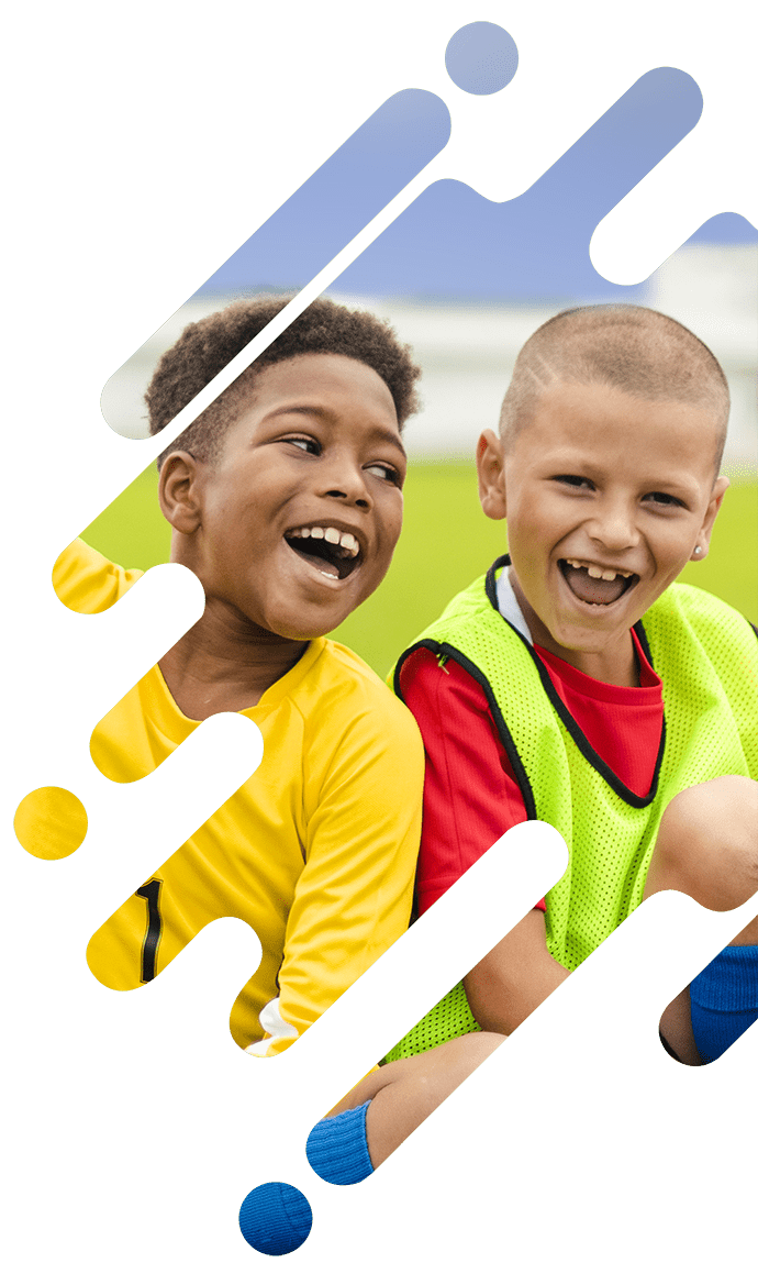 Zwei Kinder sitzen lächelnd im Gras und tragen Sporttrikots. Der Hintergrund ist bunt und abstrakt mit geometrischen Formen. Das linke Kind trägt ein gelbes Shirt, das rechte ein rotes Shirt mit einer grünen Weste.